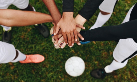 np_Top view of hands of players placed one over the other standing in a huddle_5povg0_free