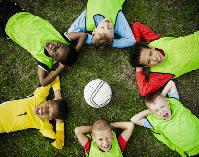 junior-football-team-lying-around-a-football-2026-01-07-23-24-42-utc