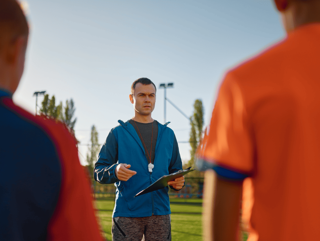 young-soccer-coach-teaching-kids-on-football-field-2026-01-06-09-03-26-utc